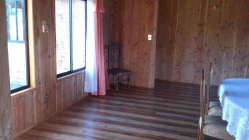 an empty room with a bed and a window at Cabañas Los Canelos Pucon, Hermosa Granja de 20 hectaréas a orillas del Río Liucura in Pucón