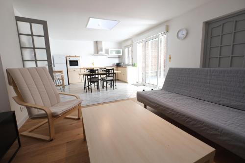 a living room with a couch and a table at Escale de 80 m2 avec cour et parking in Lille