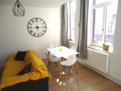 Habitación con cama, mesa y reloj en Appartement Lille/1ch/stationnement gratuit en Lille