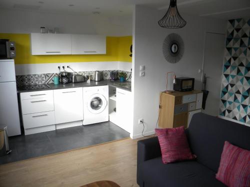 a living room with a couch and a kitchen at Apartment Lille - Proche métro - Stationnement gratuit in Lille