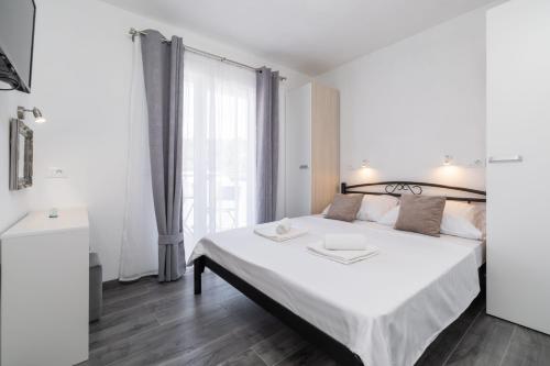 a bedroom with a white bed and a large window at MALOA One bedroom apartment in Smokvica