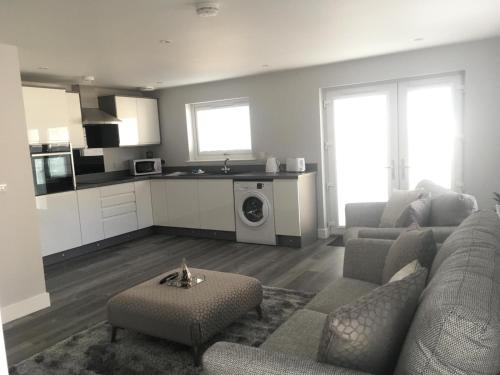a living room with a couch and a kitchen at Appin Apartment in Inverness