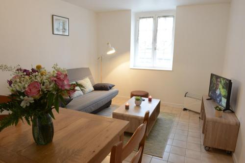 een woonkamer met een tafel en een bank bij Le Cerf-Volant in Dieppe