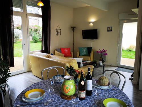 una sala de estar con una mesa con botellas de vino. en Gîtes "Le Clos de La Baie", en Paimpol