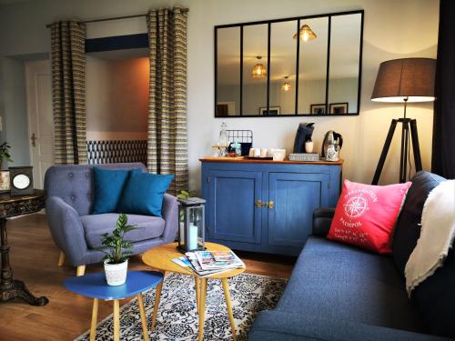 sala de estar con 2 sillas azules y mesa en Gîtes "Le Clos de La Baie", en Paimpol