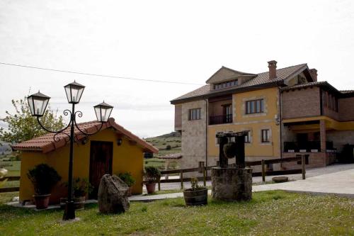 a house with a street light in front of it at Apartamentos La Gloria in Santillana del Mar