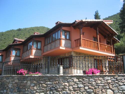 a large house with a balcony on a stone wall at Apartamentos La Montaña in Frama