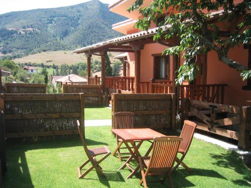 a table and chairs on a lawn in front of a house at Apartamentos La Montaña in Frama