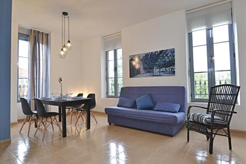 sala de estar con sofá azul y mesa en Apartamentos en la Montaña - Fuente en Segures en Benasal