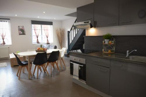 une cuisine et une salle à manger avec une table et des chaises dans l'établissement L'Ombre Dieppoise, à Dieppe