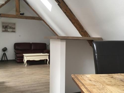 un salon avec un canapé et une table dans l'établissement Appartement L'Arédien, à Saint-Yrieix-la-Perche