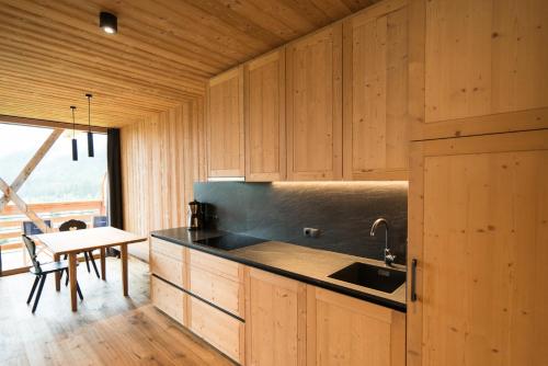una cucina con mobili in legno, un lavandino e un tavolo di Preindlerhof Haylofts a Valle Di Casies