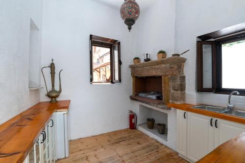 a kitchen with a sink and a fireplace at Letty's House - Old Town Luxury Mansion in Rhodes Town