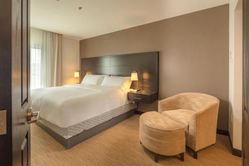 Habitación de hotel con cama y silla en Staybridge Suites - Irapuato, an IHG Hotel, en Irapuato