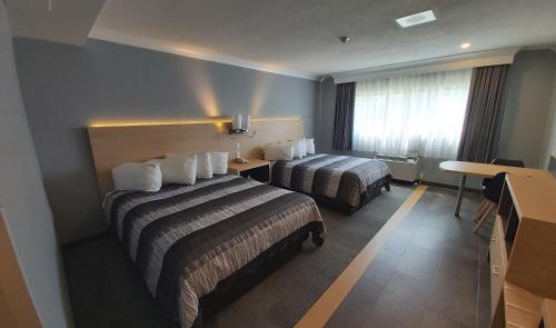 a hotel room with two beds and a desk at Americana Waterpark Resort & Spa in Niagara Falls