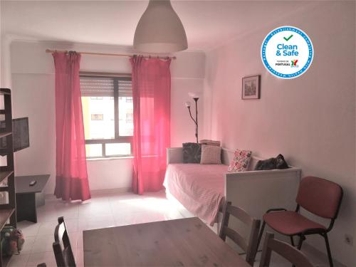 a bedroom with a bed and a window with pink curtains at Apartamento Familiar Lisboa Taguspark in São Marcos