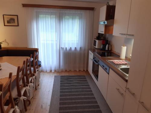 eine Küche mit einem Tisch und ein Esszimmer mit einem Fenster in der Unterkunft Haus Reason in Aurach bei Kitzbuhel