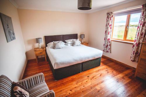 a bedroom with a large bed and a window at Moorpark Cottages in Barvas