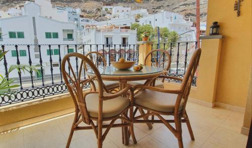 un tavolo e sedie su un balcone con vista di HD Mogan Beach Apartment a Puerto de Mogán