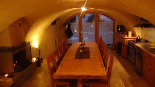 una larga mesa de madera en una cocina con encimera en Le Bacchu Ber, en Briançon