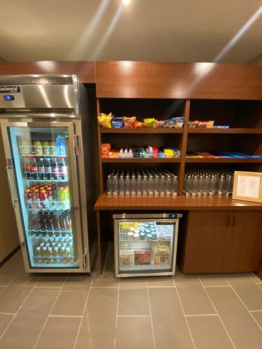 a room with a refrigerator and a shelf with drinks at Comfort Suites Midland West in Midland