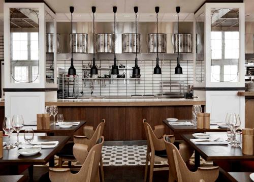 a restaurant with wooden tables and chairs and a kitchen at Villa Copenhagen in Copenhagen