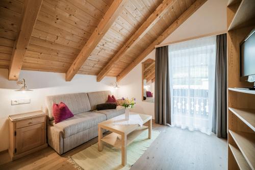 una sala de estar con un sofá y una mesa en Residence Villa Maria, en Sesto