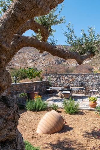 a stone wall with a bench and a tree at Yiannis Retreat in Káto Zákros