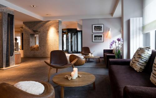 a living room with couches and chairs and a fireplace at Hotel Le Morgane in Chamonix