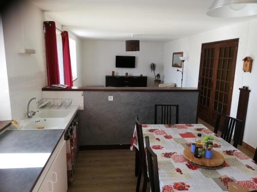 a kitchen with a table and a kitchen with a sink at gite les chaumeix in Prondines