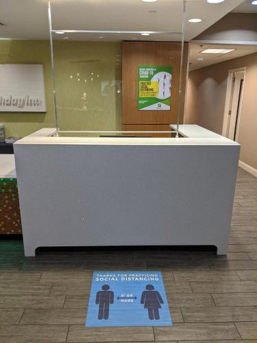 a sign on the floor next to a counter in a store at Holiday Inn Charlotte University by IHG in Charlotte