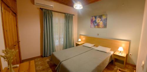 a bedroom with a bed and two tables with lamps at Villa Olive Grove and sea view in St. Spyridon Corfu