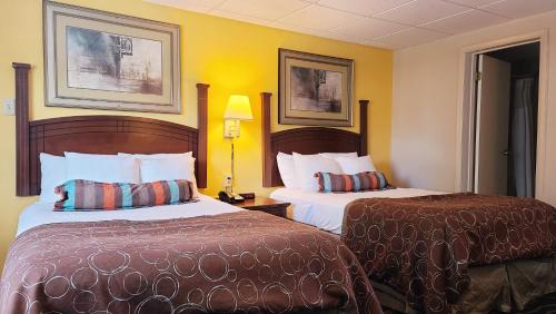 2 Betten in einem Hotelzimmer mit gelben Wänden in der Unterkunft Hampton Inn (not a Hilton Affiliate) Camp Hill - Harrisburg SW in Harrisburg