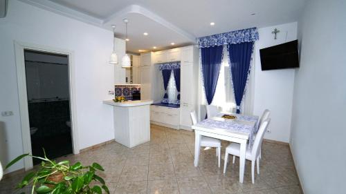 Una cocina y un comedor con mesa y sillas. en Mira Vico Apartments, en Vico Equense