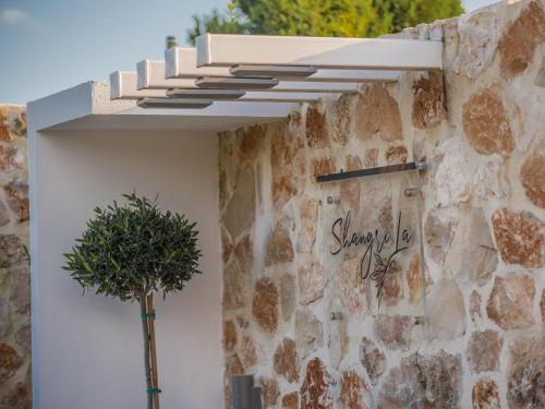 a stone wall with a window and a tree next to it at Villa Shangri-La Zakinthos in Zakynthos Town