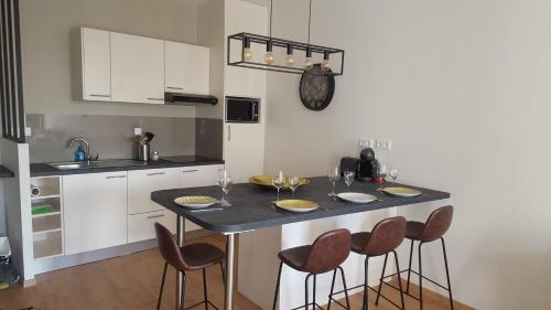 - une cuisine avec une table, des chaises et un comptoir dans l'établissement Au Martray, à Paimpol