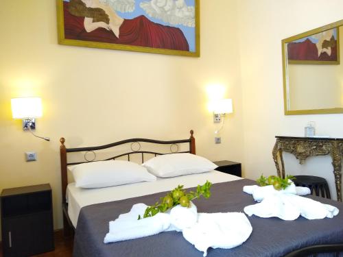 two beds in a hotel room with towels at Hermoupolis Syros Maisonette in Ermoupoli