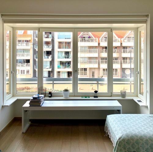 a bedroom with a bed and a large window at Appartement Giulia in Knokke-Heist