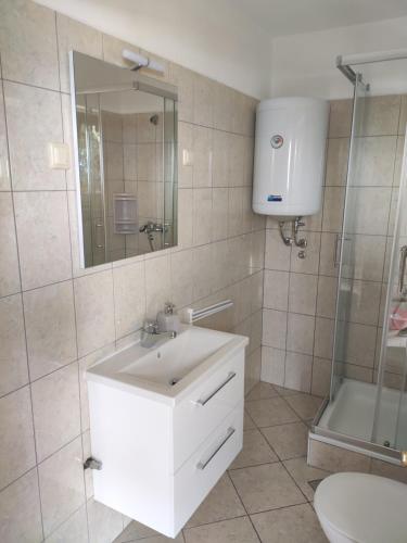een badkamer met een witte wastafel en een douche bij 2 minutes to the beach in Crikvenica