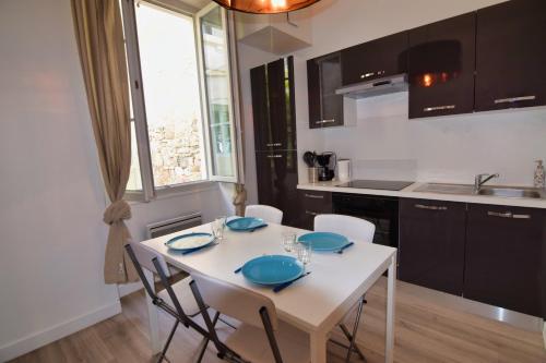 d'une cuisine avec une table blanche et des plaques bleues. dans l'établissement Atlantico - Horia, à Biarritz