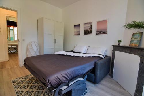 Cette chambre comprend un grand lit et une cheminée. dans l'établissement Atlantico - Horia, à Biarritz