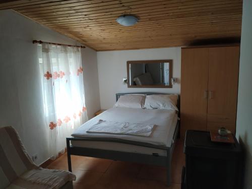 a bedroom with a bed and a chair and a mirror at Apartment Anka in Savar