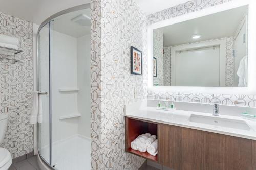 a bathroom with a sink and a mirror at Holiday Inn - Columbus by IHG in Columbus