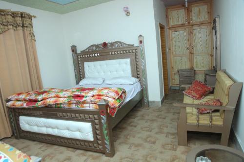 ein Schlafzimmer mit einem Bett, einem Sofa und einem Tisch in der Unterkunft Hassan Hotel Thandani in Dhudiāl