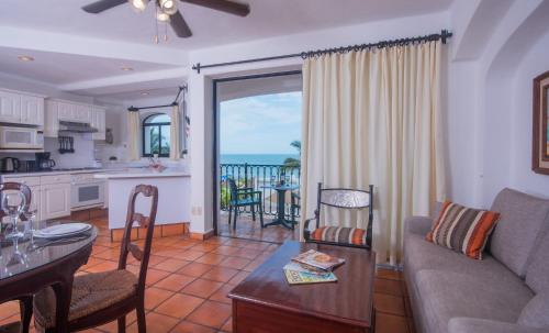 a living room with a couch and a table and a kitchen at One Beach Street Zona Romantica Puerto Vallarta in Puerto Vallarta