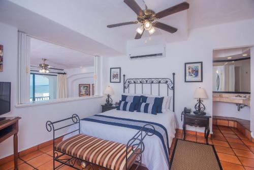 - une chambre avec un lit et un ventilateur de plafond dans l'établissement One Beach Street Zona Romantica Puerto Vallarta, à Puerto Vallarta