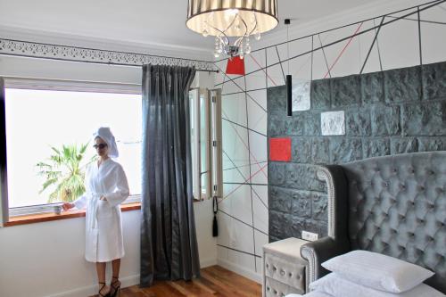 スプリトにあるGaleria Valeria Seaside Downtown - MAG Quaint & Elegant Boutique Hotelsの窓際に立つ女性
