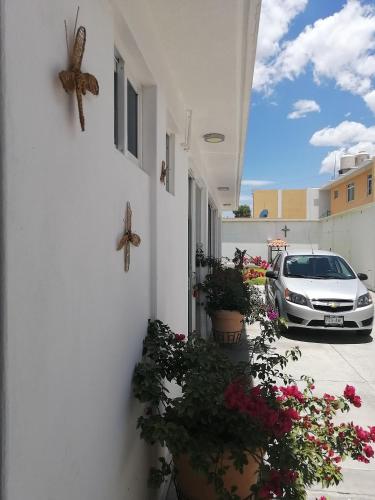 a white car parked next to a building with flowers at Lepa Mukawa ( Descansa Bonito) in San Juan Teotihuacán