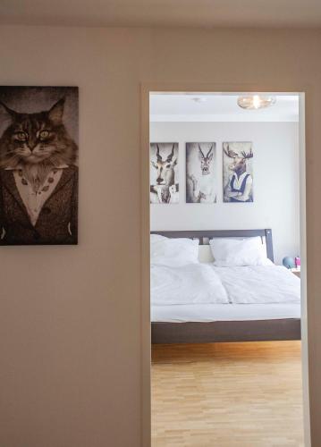 a cat is sitting on a bed in a bedroom at Neue FEWO Juventia (87 m²) - Neuseenland ganz nah! in Markkleeberg