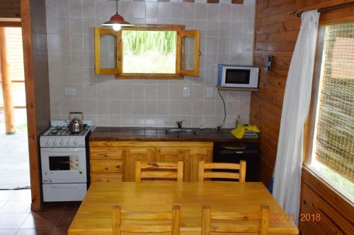 a kitchen with a table and a stove and a microwave at Terrazas de Uspallata in Uspallata